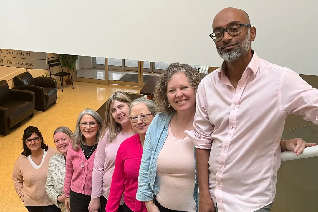 Team members posing on a staircase for Pink Shirt Day in South Surrey White Rock.